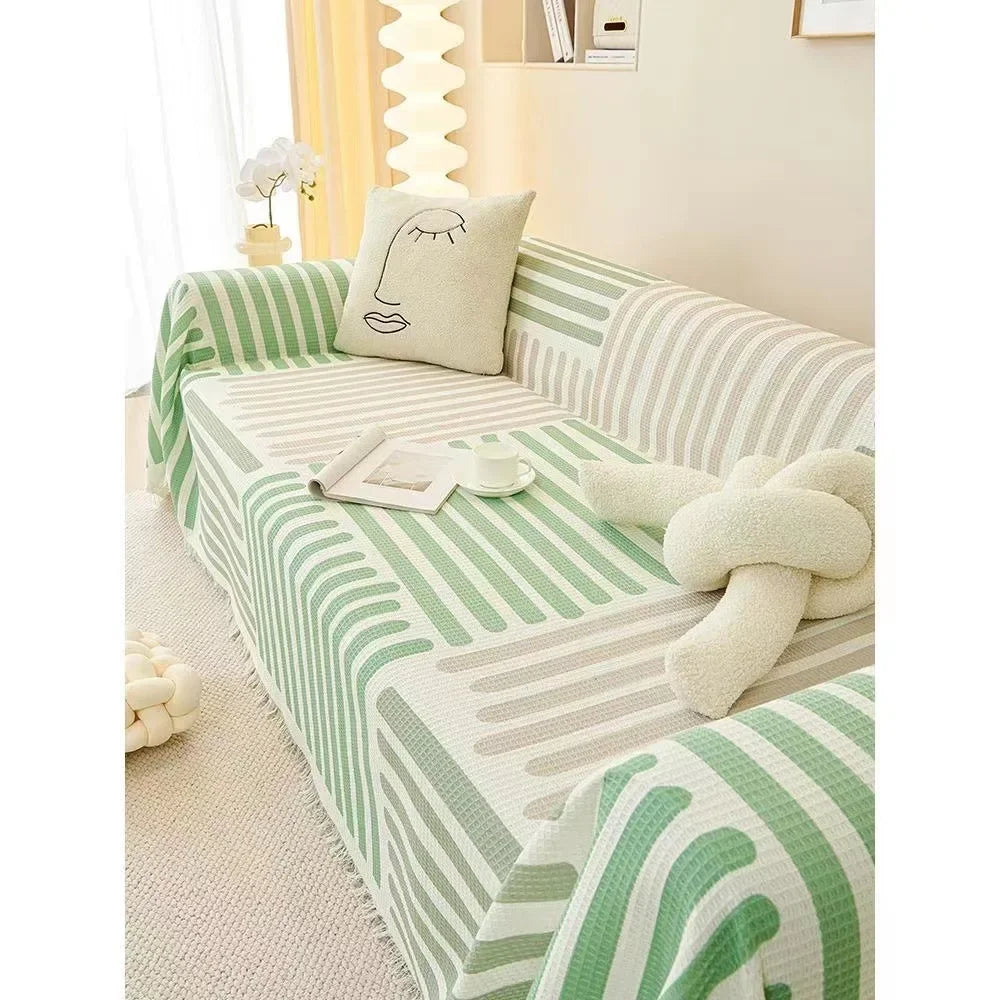 Green and white striped sofa with decorative pillows in a living room setting.