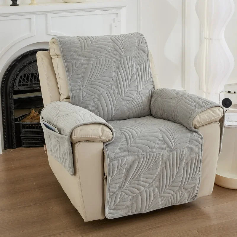 Grey recliner cover on beige recliner chair with leaf pattern in a living room setting.
