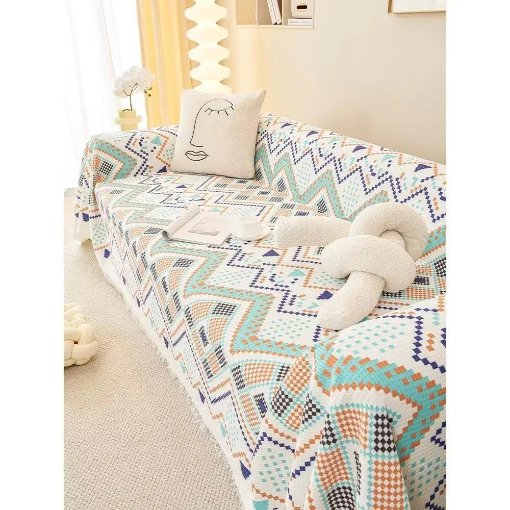 Patterned blue reef sofa cover on a sofa with decorative pillows in a room setting.