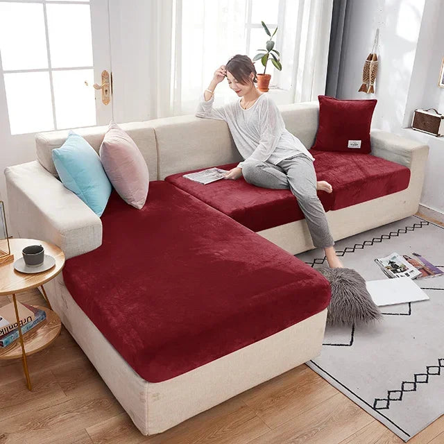 Woman sitting on a sectional sofa with red cushions in a bright living room.