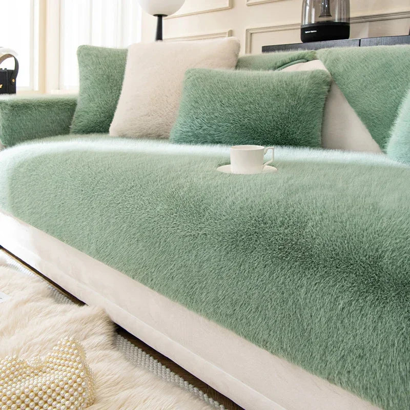 Green sofa cover on a modern sofa with a cup and saucer in a living room setting.