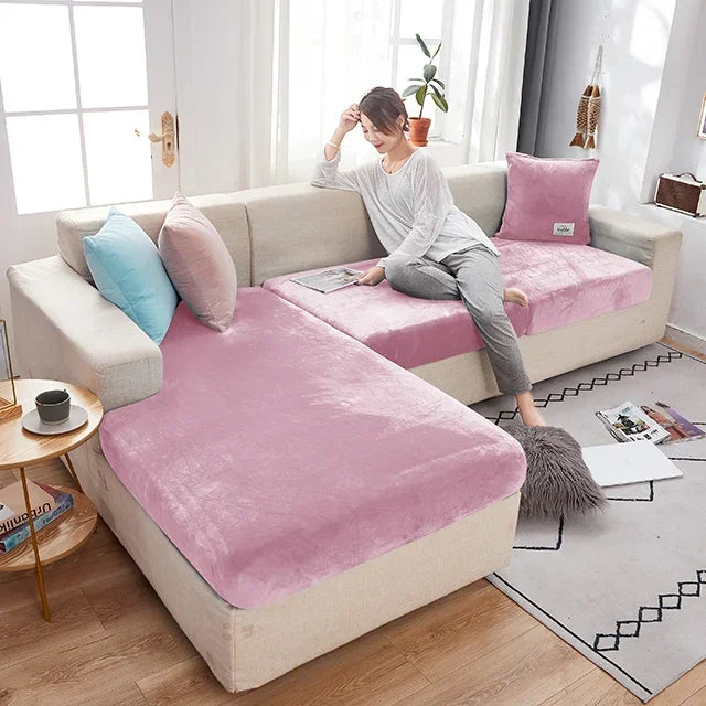 Woman sitting on a sofa with pink and beige covers in a bright living room.