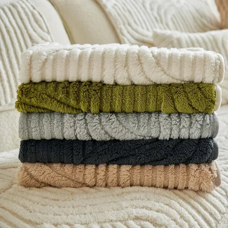 Stack of folded couch covers in various colors on a beige surface.