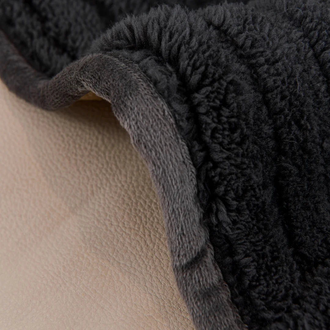 Close-up of a dark gray textured fabric on a beige surface