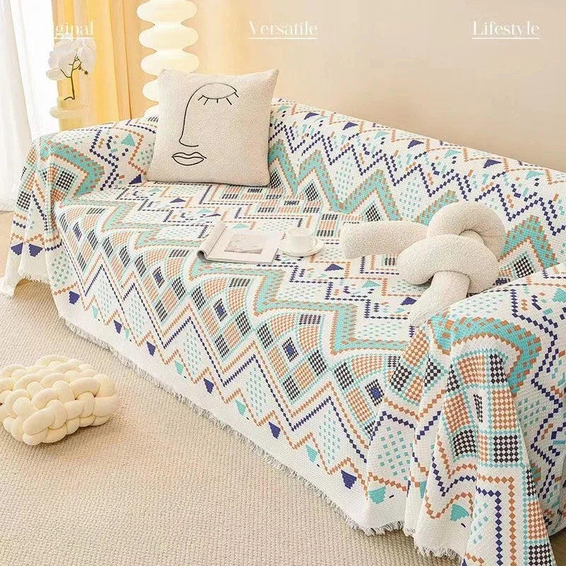 Geometric patterned throw blanket on a sofa with decorative pillows in a cozy living room.