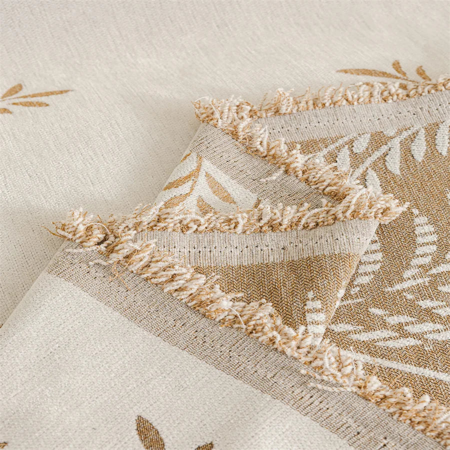 Close-up of a textured fabric with geometric pattern and fringes on a neutral background