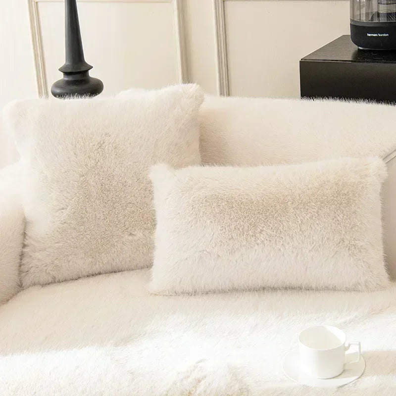 White fluffy pillows on a sofa with a blurred background