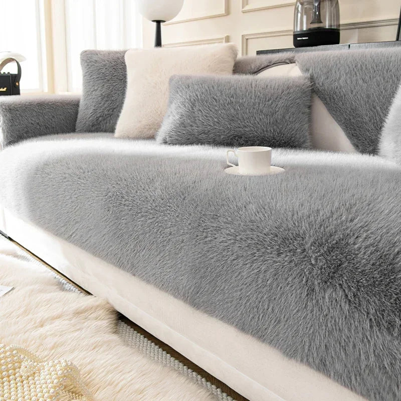 Grey fluffy sofa cover on a white sofa in a living room setting.