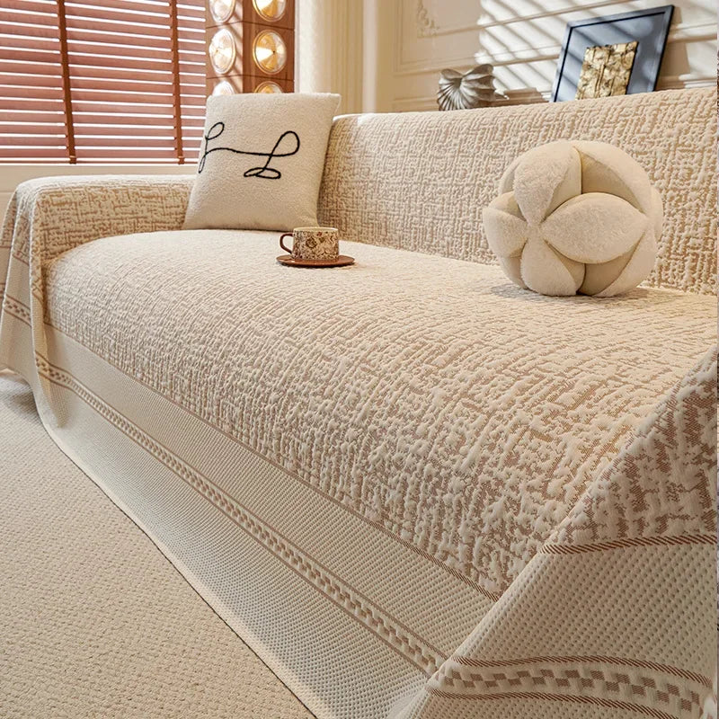 Beige sofa with decorative pillows and a cup in a living room setting