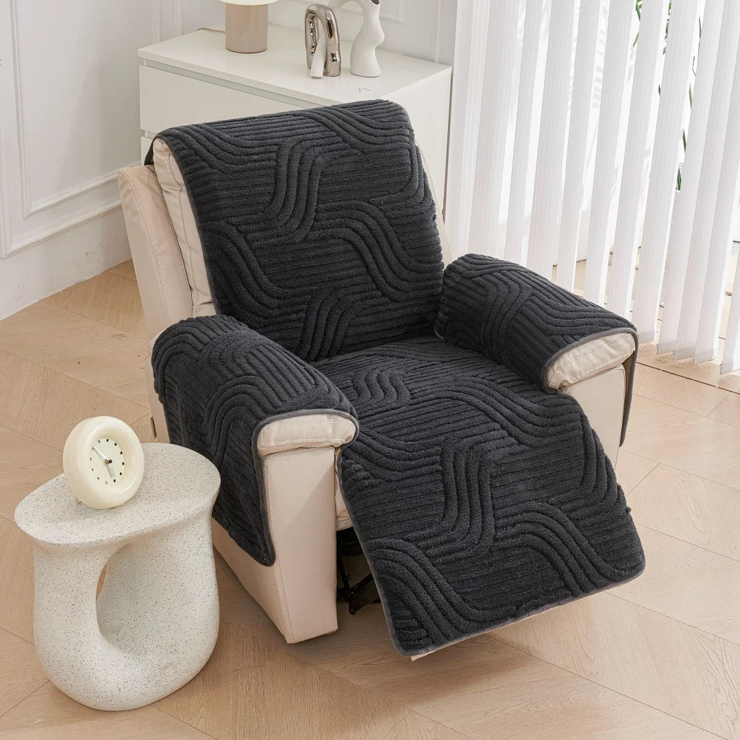 Chair with a dark gray textured cover in a room with a small table and decor items.