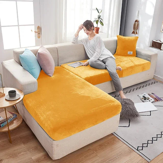 Woman sitting on a sectional sofa with yellow cushions in a living room.