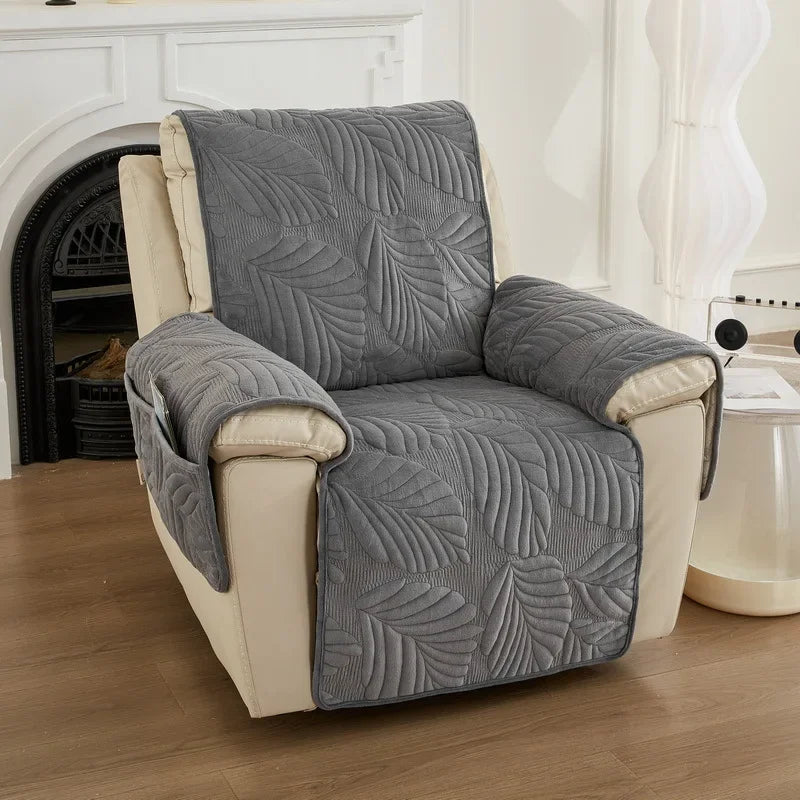 Dark grey leaf-patterned recliner cover on a beige recliner chair in a living room setting.