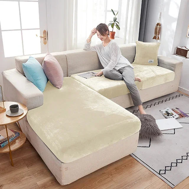 Woman sitting on a beige sectional sofa with a textured cover in a bright living room.