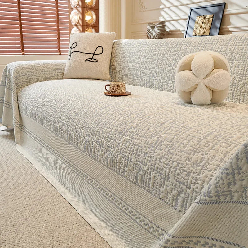 Beige sofa with decorative pillows and a cup in a living room setting