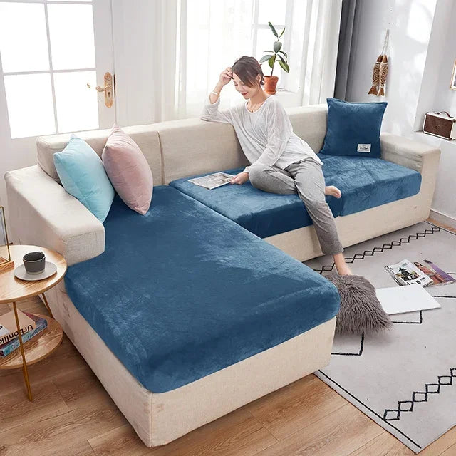 Woman sitting on a sectional sofa with blue cushions in a living room.