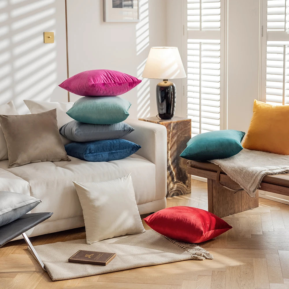 Colourful pillows on a white sofa in a bright living room with wooden floor.