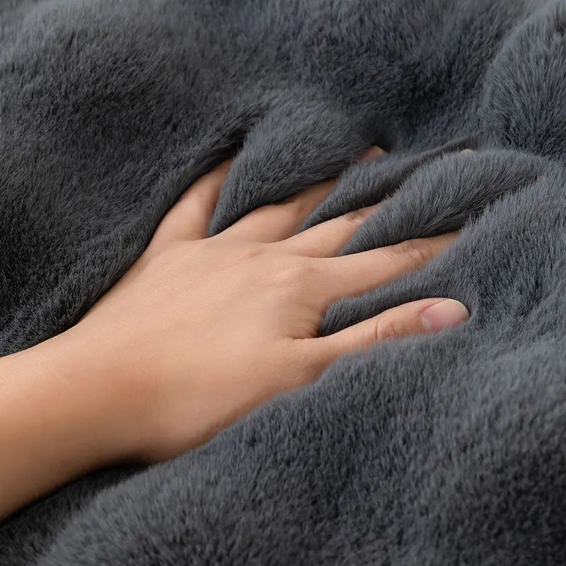 Hand touching a soft gray blanket