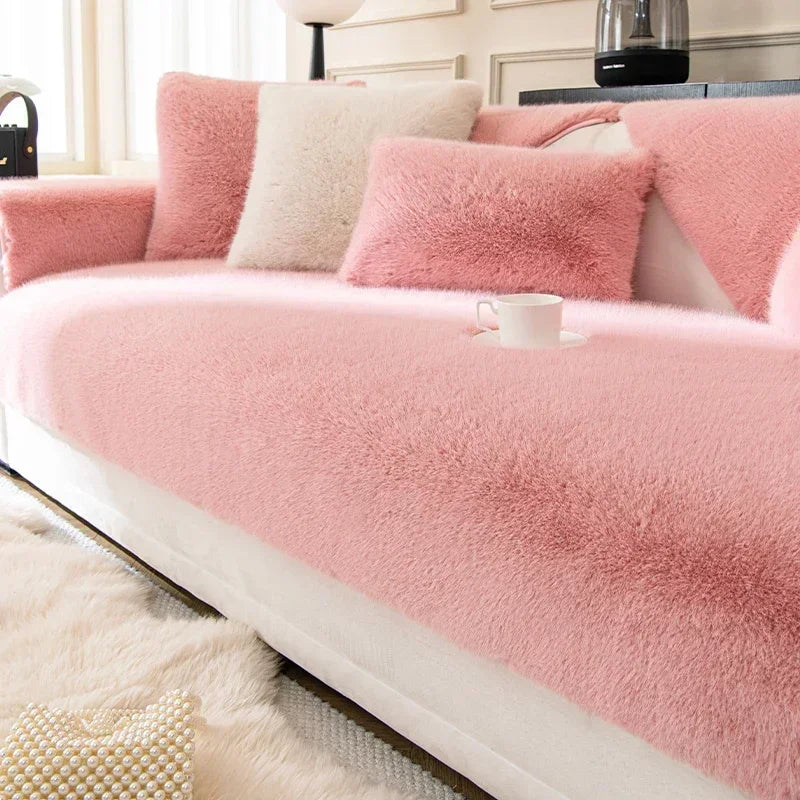 Pink sofa with fluffy cushions in a living room setting