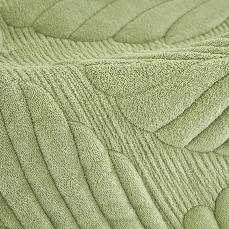 Close-up of a textured green fabric with leaf patterns