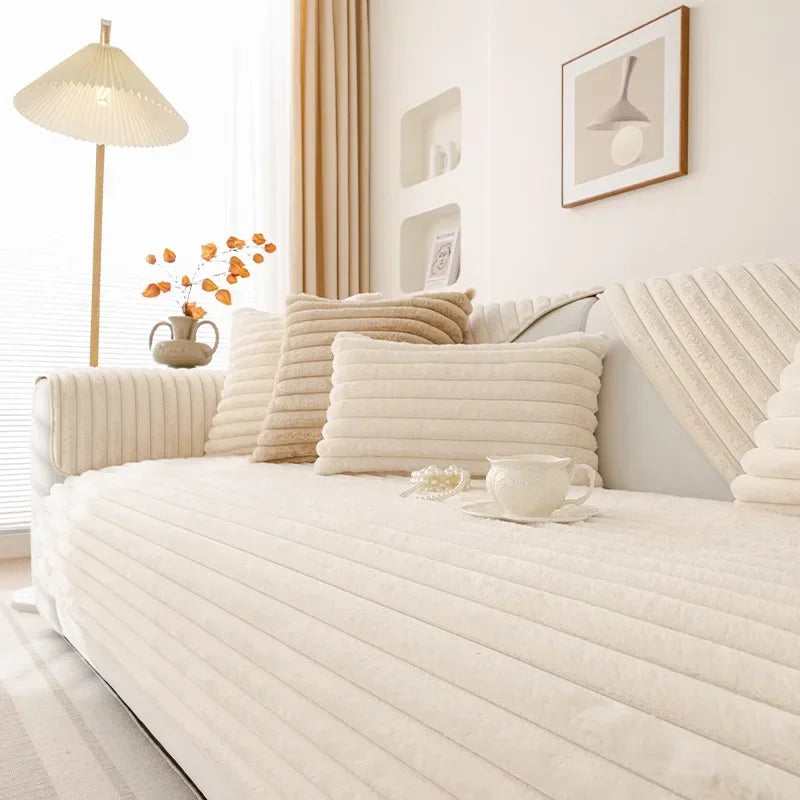 Neat white ribbed couch cover decorative pillows in a bright bedroom.