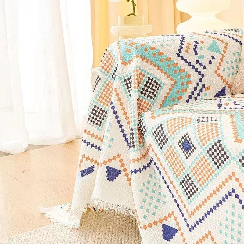 Colorful patterned blanket draped over a couch in a living room setting.