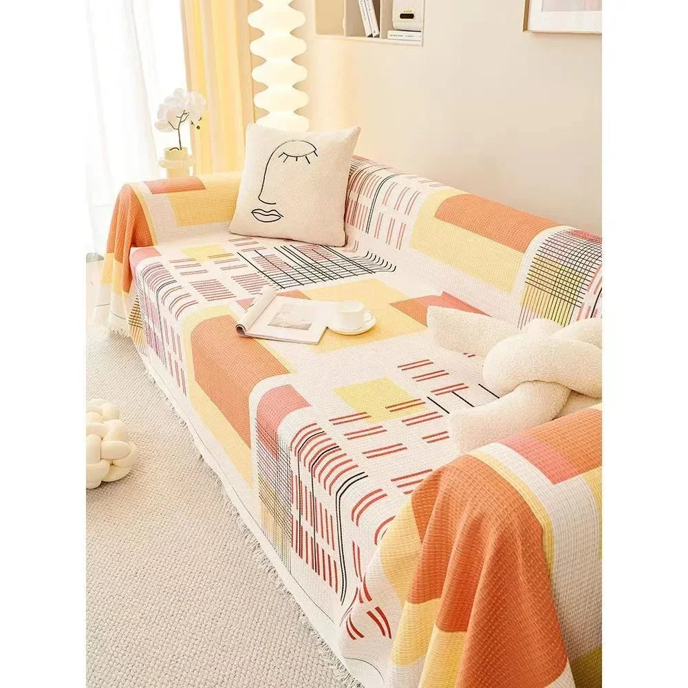 Colorful sunset patterned sofa cover on a sofa with decorative pillows and a small table.