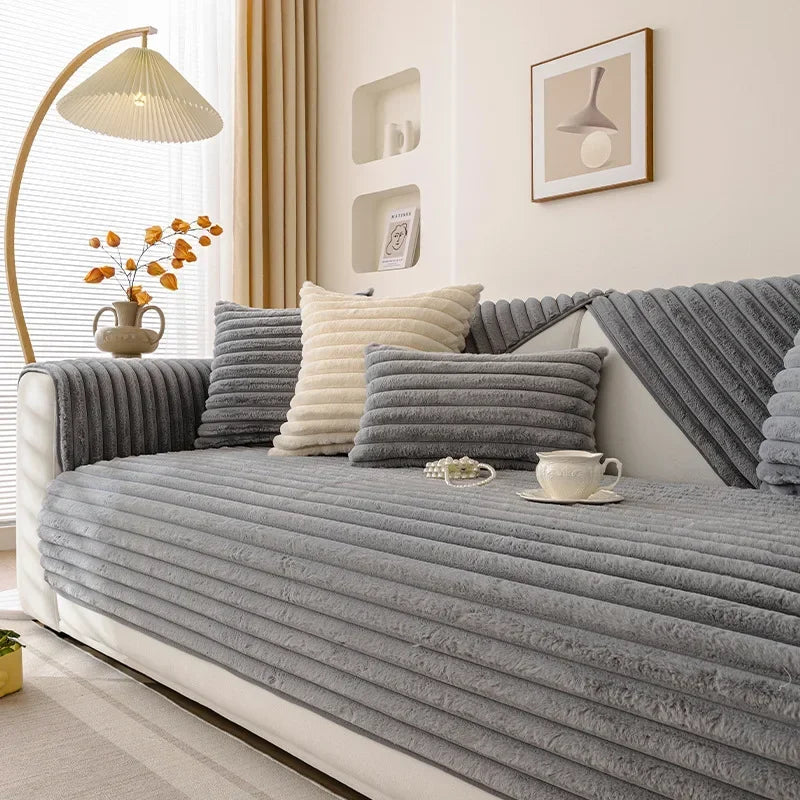 Grey sofa cover on a sofa with decorative pillows in a living room setting.