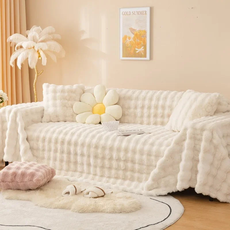 White plush faux rabbit bubble sofa cover on a couch with decorative pillows in a living room setting.