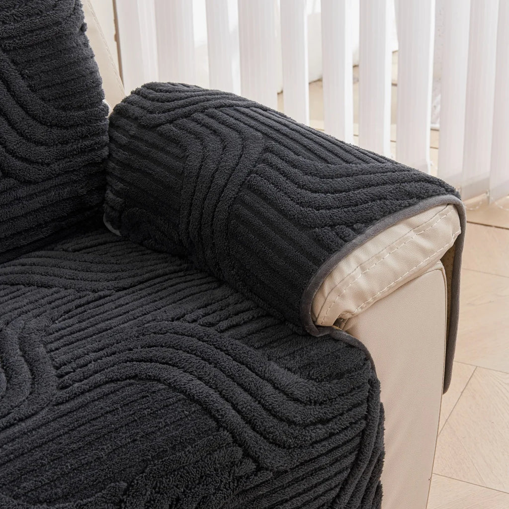 Dark gray textured blanket draped over a chair with a light-colored background