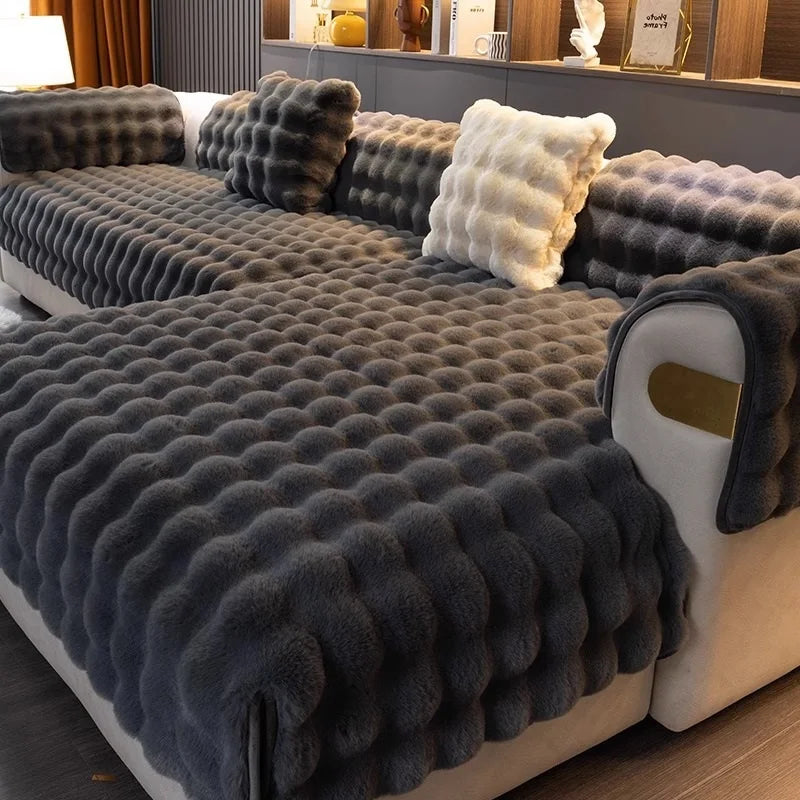 Grey textured plush soft sofa with decorative pillows in a living room setting