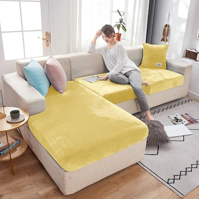 Woman sitting on a yellow and beige sectional sofa in a living room.